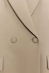 Blazer cruzado de color verde oscuro, con cuello de solapa, manga larga, bolsillos delanteros con solapa y cierre frontal con dos botones dorados.