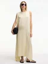 Vestido largo color crema, de corte amplio y holgado, con cuello redondo y tajos verticales a los costados.