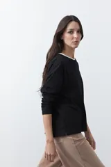 Remera de manga larga en color blanco, con calce relajado y diseño minimalista. Presenta un cuello redondo clásico y puños rectos, ideal para usar como prenda base en capas.