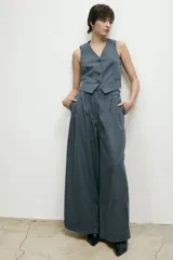 Pantalón sastre de corte wide leg, color gris, con pinzas delanteras y bolsillos laterales.