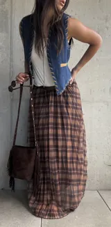 Falda larga plisada con estampado de cuadros en tonos camel y marrón, confeccionada en tejido liviano con cintura elástica.