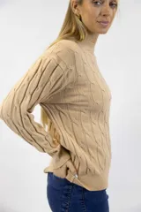 Sweater tejido color beige con cuello semialto, manga larga y diseño de trenzas en relieve.