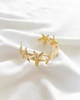 Pulsera dorada con diseño de estrellas de mar.