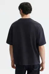 Remera oversize color negro de algodón con cuello redondo y mangas cortas amplias.