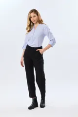 Pantalón de gabardina marrón, de corte recto con pinza en el bajo y detalles de botones en los tobillos.