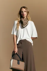 Remera de calce relajado con silueta fluida, confeccionada en tejido de viscosa con elastano. Presenta cuello redondo, mangas cortas y un diseño minimalista de caída suave.