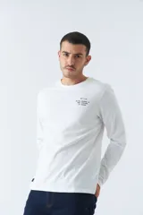 Remera verde militar de manga larga, cuello redondo y corte recto. Estampa pequeña en el pecho con texto en negro.