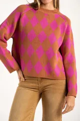 Sweater de punto con diseño de rombos en colores fucsia y tostado, cuello redondo y mangas largas.