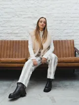 Pantalón de tiro alto con rayas verticales grises y blancas, corte recto y ruedo con dobladillo.