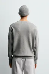 Jersey de punto con textura acanalada, cuello redondo y manga larga. Presenta un corte regular fit con acabados en rib en puños y bajo.