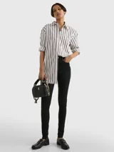 Pantalón de jean negro, corte skinny, con cierre de botón y cremallera, cinco bolsillos y parche de Tommy Hilfiger en la parte posterior de la cintura.