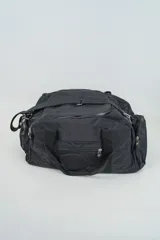 Bolso de viaje color negro con múltiples compartimentos con cierre, doble asa de mano y correa ajustable para el hombro.