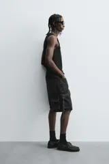 Camiseta sin mangas (tank top) negra, de corte slim fit, con cuello redondo de efecto doble.