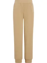 Pantalón de jogging color beige, de corte relajado y tiro medio, con puños ajustados en los tobillos.