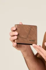 Billetera marrón de ecocuero con costuras en contraste y diseño geométrico.