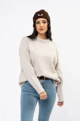 Sweater de punto en color beige, con cuello redondo y diseño de calce relajado. Presenta puños y ruedo acanalados.