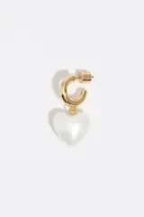 Caravanas doradas con argolla tipo criolla y dije colgante en forma de corazón color blanco perlado.