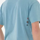 Remera de manga corta color crema, con cuello redondo y un pequeño estampado frontal con el logo de Rip Curl en tonos rosados y negros con efecto burbuja.