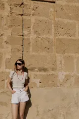 Shorts de jean tiro medio, corte mom fit, con bajo deshilachado y forro de bolsillos delanteros estampado a cuadros que asoma por debajo.