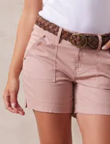 Short color rosa viejo de algodón con cinturón trenzado de cuero marrón. Tiene pretina con pasadores, cierre y doble abotonadura. Delantera y trasera con bolsillos.