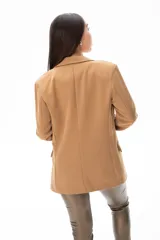 Blazer color camel de corte clásico, con solapas de muesca, cierre frontal con dos botones, bolsillos laterales con solapa y mangas largas. Confeccionado en tejido suave al tacto compuesto por poliéster, viscosa y spandex.
