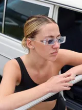 Lentes de sol rectangulares con marco transparente y cristales negros.