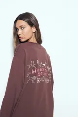 Remera de manga larga en color blanco, con corte relajado y cuello redondo. Presenta un pequeño estampado gráfico en la parte inferior frontal con la frase 'WHO WH WHO?' y un dibujo de un perro.