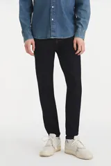 Pantalón de jean de hombre, color azul oscuro (rinse), con calce ajustado en cadera y muslos, pierna súper ajustada y tiro medio.