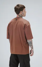 Remera de corte oversize y largo cropped, color marrón mocca, con cuello redondo y mangas cortas con hombros caídos.