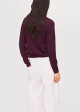 Jersey de punto fino color bordó, con cuello drapeado, mangas largas y diseño recto.