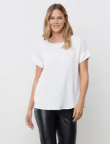 Blusa blanca de manga corta con cuello a la base, confeccionada en tejido crepe.