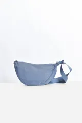 Riñonera tipo banana color celeste, con correa regulable del mismo material.