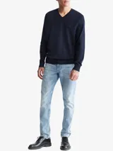 Sweater de punto liso color azul marino, con cuello en V y manga larga. Presenta un pequeño monograma bordado en el pecho.