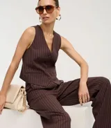 Pantalón de vestir de corte recto, color marrón oscuro con finas rayas verticales en tono más claro. Presenta un calce sastrero y bolsillos laterales.