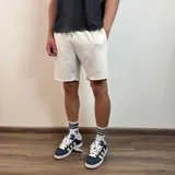 Short de algodón gris melange con cintura elástica y cordón de ajuste, de corte holgado y ruedo sin costura.