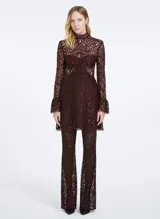 Pantalón largo acampanado de encaje color borgoña con hilos metálicos, cintura alta y cierre lateral invisible.