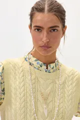 Chaleco amarillo de hilo con diseño trenzado.