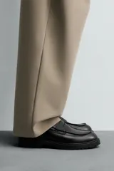 Mocasín de vestir negro con detalle de antifaz en la parte superior y suela track.