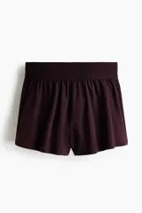 Short deportivo de doble capa color bordó, de corte estándar con cintura elástica fruncida y calza incorporada con bolsillo portacelular.