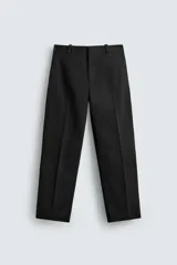Pantalón chino de corte oversized confeccionado en tejido de algodón con estructura twill. Presenta bolsillos frontales, bolsillos traseros de vivo y cierre frontal con cremallera y gancho metálico oculto.