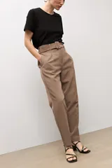 Pantalón sastrero color topo, de corte recto, con pinzas en la parte delantera y cinturón del mismo género con hebilla cuadrada.