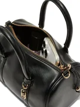 Mini bolso de viaje negro de cuero sintético ultrasuave, con formato cilíndrico, asas superiores y correa bandolera ajustable y desmontable con herrajes dorados.