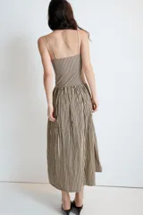 Vestido midi de popelín con estampado de rayas verticales. Presenta escote recto con detalle de pliegues, tirantes finos y falda con corte evasé. Incluye cierre lateral con cremallera oculta.