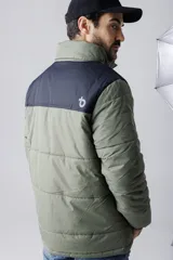 Campera puffer azul marino con canesú azul más claro en la parte superior y capucha. Cierre frontal con cremallera y bolsillos laterales.