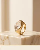 Anillo de bronce bañado en oro, de diseño ancho y moderno, con un gran cristal de Swarovski facetado en forma de rombo invertido.