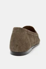 Mocasín de mujer confeccionado en serraje, con diseño de antifaz en el empeine y punta redonda. Presenta una suela plana de 2 cm.