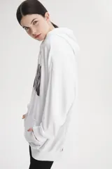 Buzo hoodie blanco de calce holgado con estampado de rosas y logo de Levi's en el pecho.