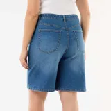 Bermuda vaquera de tiro alto con diseño amplio tipo bermuda, confeccionada en denim azul con lavado medio. Cuenta con cierre de botón y cremallera, y bolsillos delanteros y traseros clásicos.