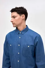 Camisa de corte regular fit confeccionada en algodón, con cuello solapa clásico, cierre frontal de botones y dos bolsillos frontales en el pecho.