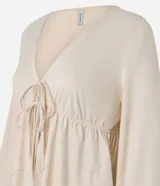 Blusa color crema con escote en V, mangas largas y lazo en el busto.